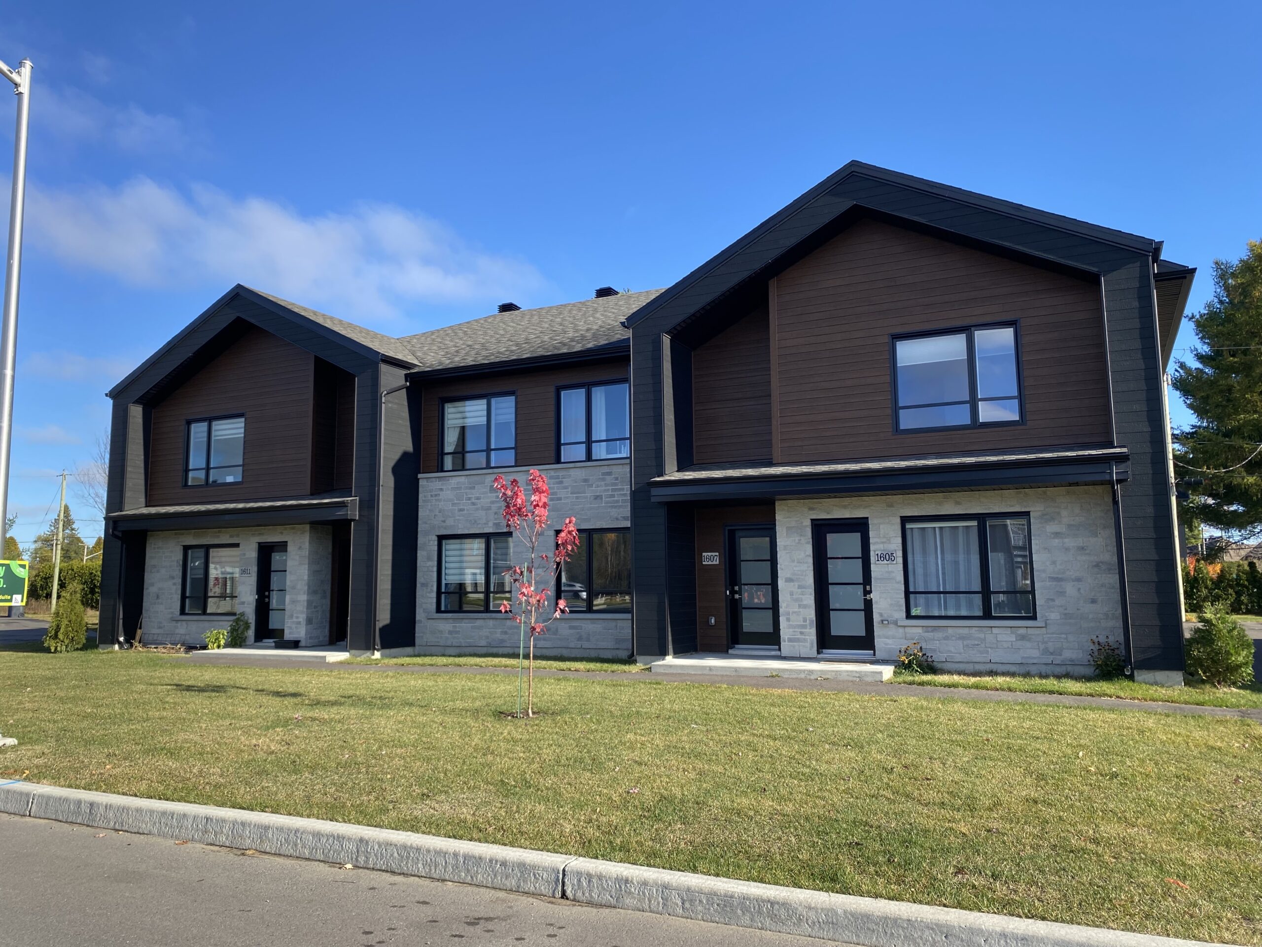 Immeuble locatif moderne avec façade en brique et revêtement brun à Trois-Rivières